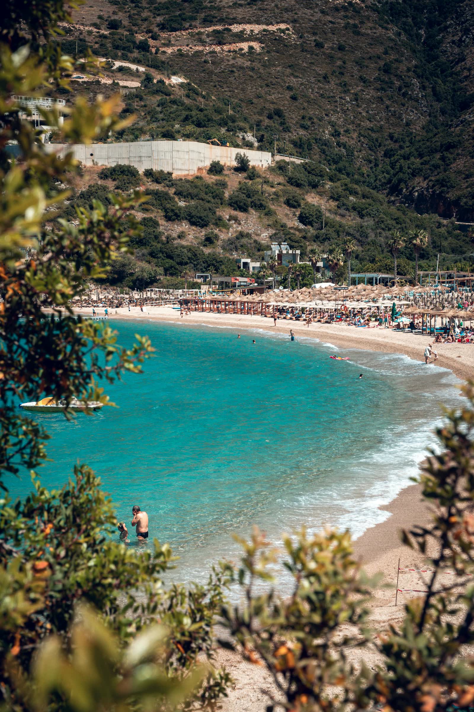 Aerial view of straw parasols on the Saranda pebbles