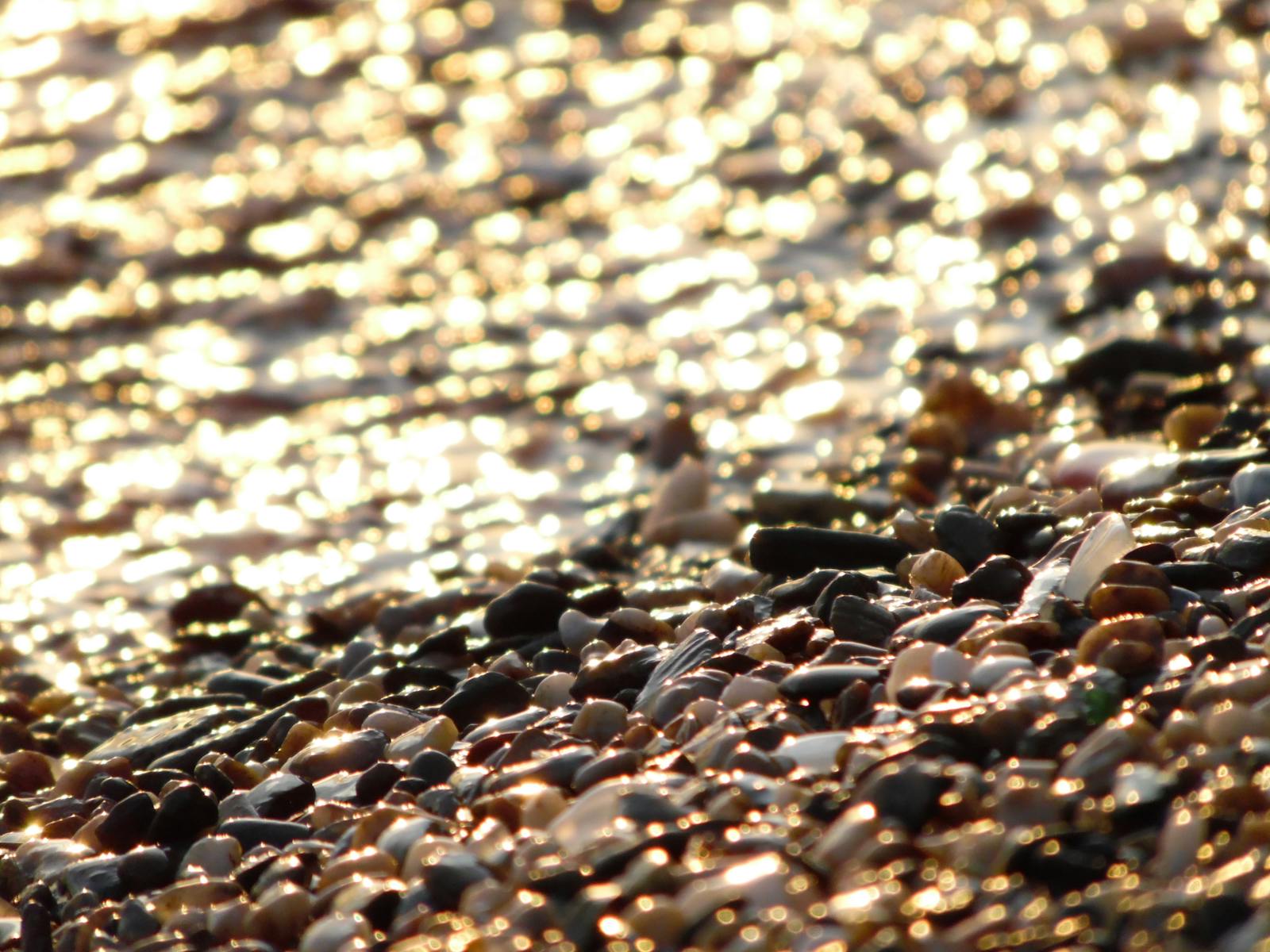 Clear water lapping the Saranda pebbles, macro detail