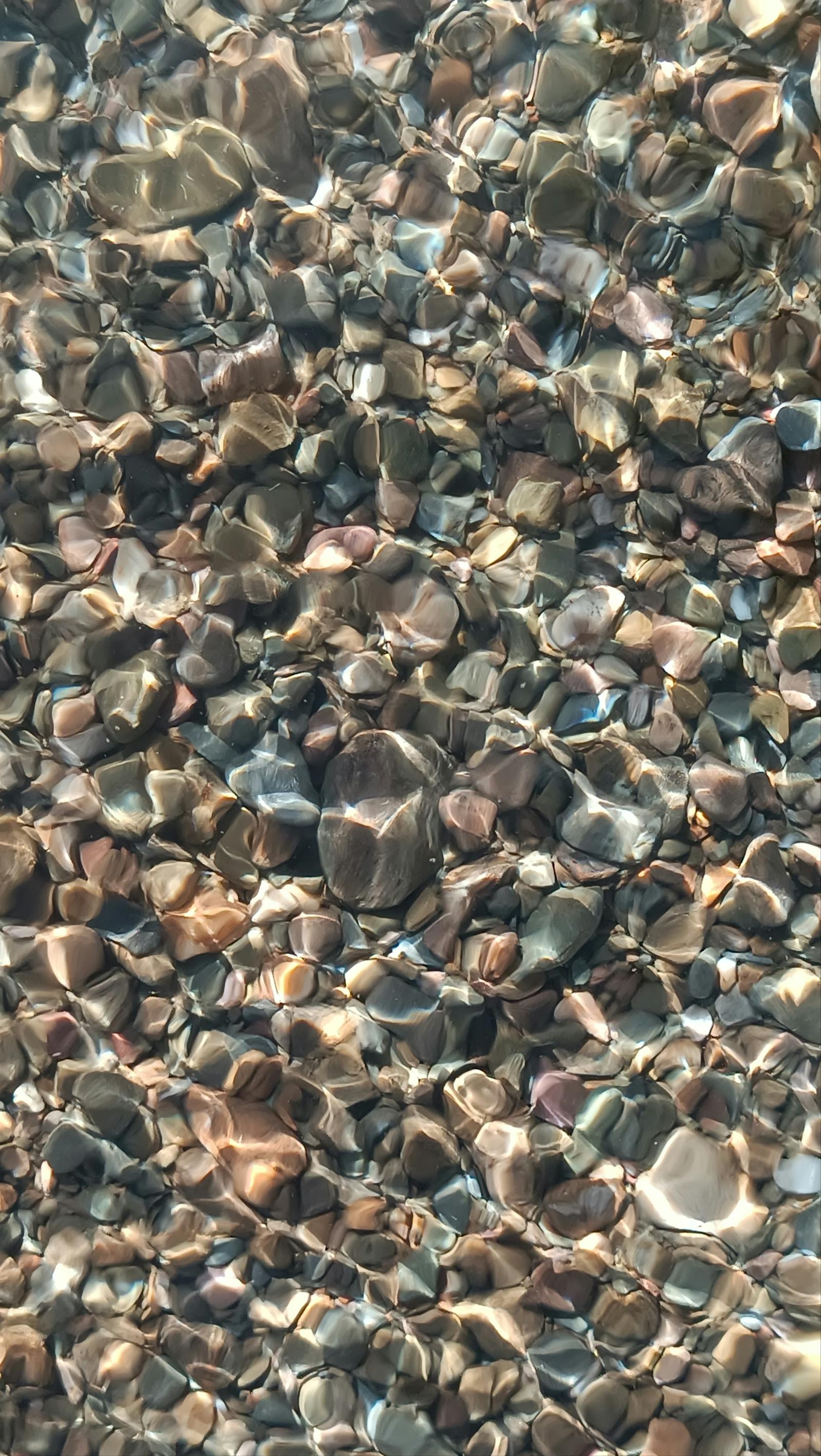 Crystal clear Ionian water over pebbles